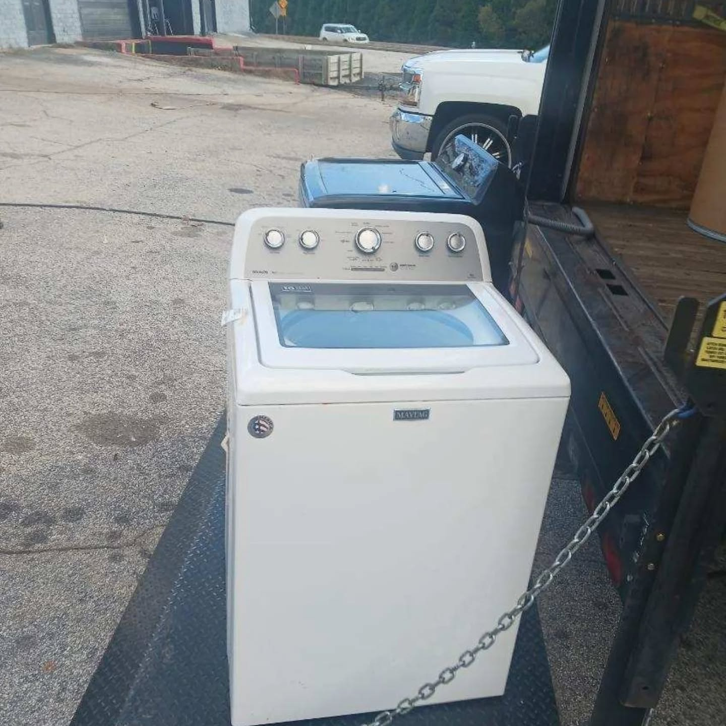 Appliance loaded on flatbed trailer for removal